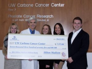 General Manager Skip Harless and Hilton Madison associates present a check to the University of Wisconsin Carbone Cancer Center